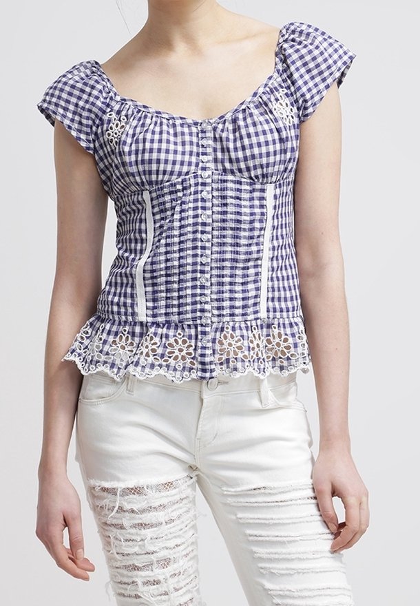 Blouse peplum à carreaux bleus et blancs avec manches courtes, fermeture à boutons et détails en dentelle à l'ourlet. Tissu en mélange de coton, design ajusté.