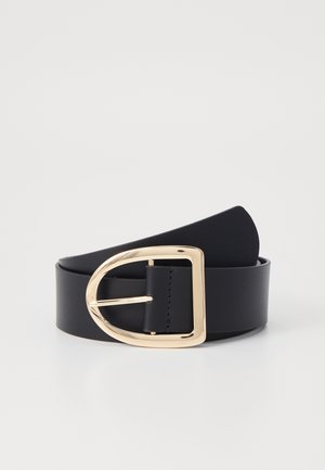 Ceinture en cuir noir enroulée avec une grande boucle rectangulaire dorée brillante sur un fond clair uni.