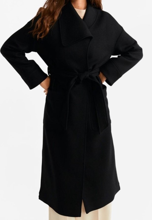 Černý vlněný kabát s velkým límcem, širokými rukávy, páskem v pase a předním rozparkem, s hladkou texturou a minimalistickým designem.