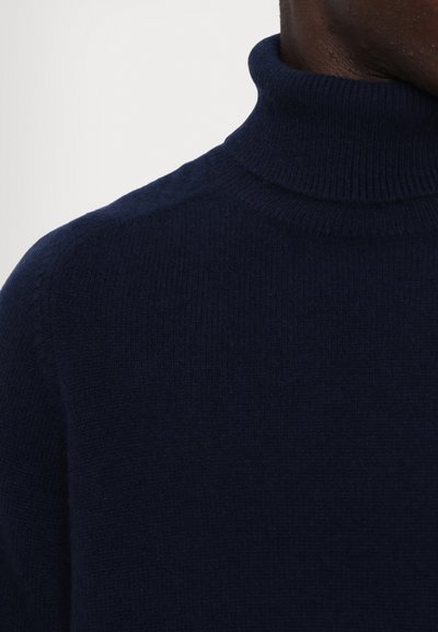 Navy blue turtleneck sweater made of soft knit fabric. Features a fitted design and ribbed neck for added texture and warmth.