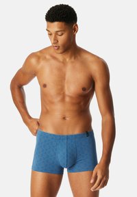 Blue boxer shorts with a geometric pattern, made of soft fabric, featuring a front pouch and an elastic waistband for comfort.