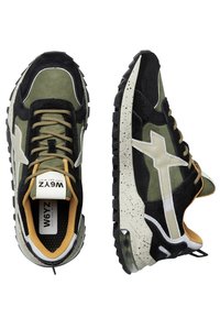 Sneaker verdi e neri realizzati in materiali scamosciati e in rete. Accenti bianchi, suola testurizzata con motivi macchiati e lacci beige.