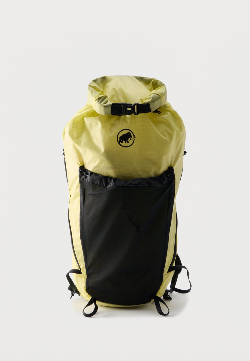 Ελαφρύ κίτρινο σακίδιο πεζοπορίας με μαύρη μπροστινή τσέπη, κλείσιμο τύπου ρολού με πόρπη και λογότυπο μαστόδοντα στο κέντρο της μπροστινής πλευράς.