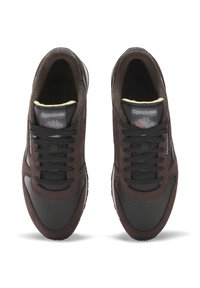 Donkerbruin suede en zwart leren sneakers met geperforeerde neus, textuurpanelen en zwarte veters. Logo op de tong, gevoerde kraag.