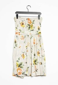 Olkaimaton kukkakuosisempi mekko, jossa on beige tausta ja värikkäitä oransseja, keltaisia ja vihreitä kukkia; laskostettu muotoilu ja vyötäröä korostava malli.