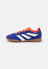 Blue athletic shoe with white stripes, orange laces, mesh upper, and gum rubber sole. Features rounded toe and cushioned collar.