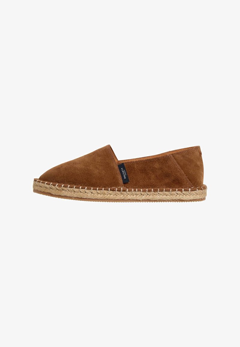 Espadrille en daim marron à enfiler, avec un bout arrondi, une semelle en jute naturelle et des coutures le long du bord. Pas de marque visible sauf une petite étiquette.