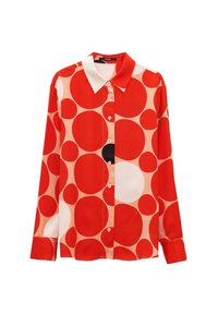 Chemise à manches longues boutonnée avec un col blanc, présentant un motif audacieux de grands cercles rouges, blancs et un noir sur un fond clair.