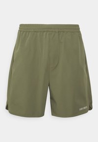 Shorts vert olive avec ceinture élastique, coutures décoratives, fentes latérales et logo blanc "LES DEUX" sur l'ourlet inférieur.