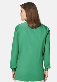Grünes Langarmshirt aus Baumwollmischung, mit lockerer Passform, klassischem Kragen und geknöpften Manschetten, mit glatter Textur.