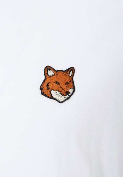 Maglietta bianca con un ricamo di testa di volpe nei colori arancione e nero. Il design presenta dettagli facciali curati e una finitura texture.