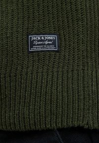 Dunkelgrüner gestrickter Pullover mit strukturierten Rippdetails, ausgestattet mit einem schwarzen Etikett, auf dem "JACK & JONES Superior Apparel" steht.