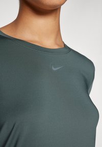 Sötétzöld Nike rövidujjú sportpóló. Kerek nyakkivágással és diszkrét szürke logóval a mellkas felett. Simogató, rugalmas anyag.