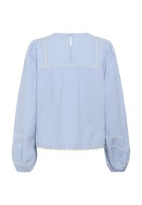 Blusa azzurro chiaro con maniche lunghe a sbuffo, dettagli scallop e chiusura a oblò sul retro. Tessuto liscio con delicate cuciture.