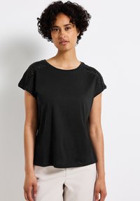 T-shirt nero a maniche corte con dettagli in pizzo sulle spalle, scollatura rotonda e vestibilità comoda, realizzato in un tessuto morbido e liscio.