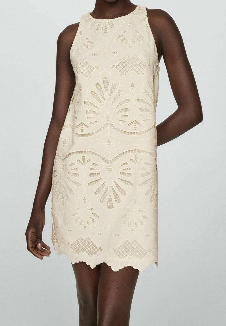 Robe en dentelle crème avec motif floral, design sans manches, ourlet festonné et détails découpés complexes sur l'ensemble.