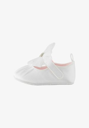 Chaussure de bébé blanche à semelle souple, équipée d'une bride à scratch et d'un délicat nœud sur le dessus.