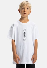 Biele bavlnené tričko s voľnejším strihom, s monochromatickou grafickou potlačou na prednej strane a krátkymi rukávmi.