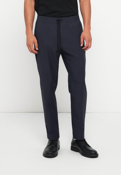 Pantalones jogger de color navy hechos de una tela suave, con cintura elástica y cordón, bolsillos laterales y un diseño de pierna estrecha.