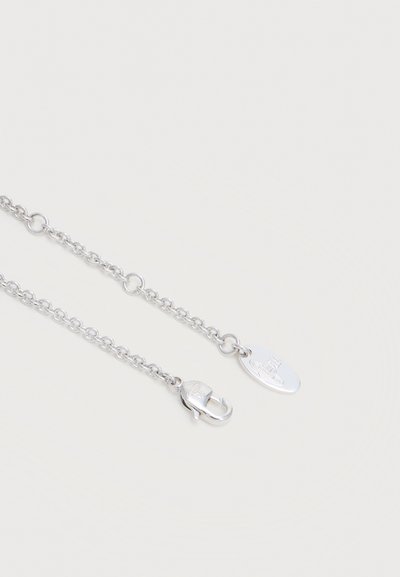 Ασημένιο κολιέ με αλυσίδα, οβάλ κούμπωμα και μικρή οβάλ χαραγμένη πλακέτα σε ανοιχτό φόντο.