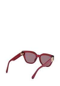 Röda kattögon-solglasögon med mörka linser och detaljer i guld på bågens ändar, uppställda på en vit bakgrund.