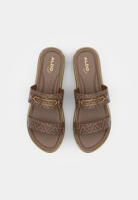 Brązowe klapki na płaskiej podeszwie z dwoma wzorzystymi paskami, teksturowaną wkładką i złotymi akcentami. Trwały materiał z geometrycznymi wzorami.