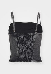 Top a spalline nero e grigio con una sezione inferiore in denim scuro texturizzato, caratterizzata da un design smocked, e una parte superiore nera liscia.