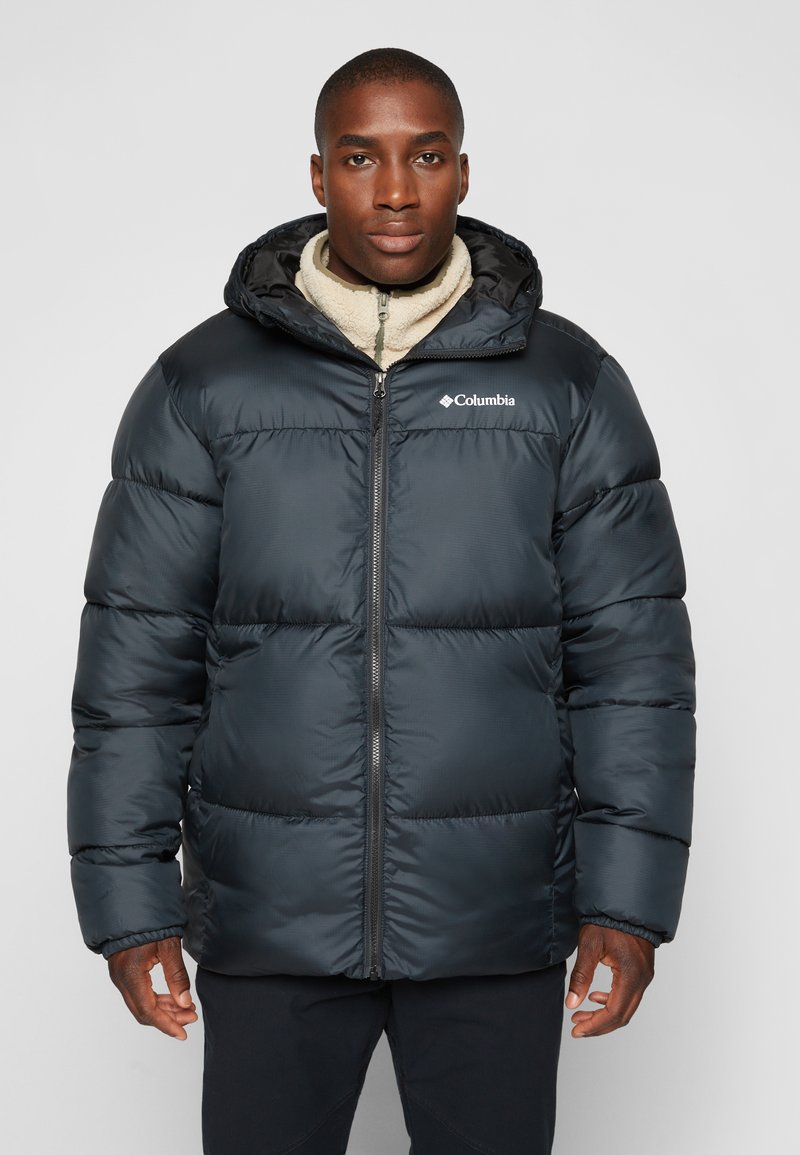 Chaqueta acolchada negra con cremallera frontal y capucha, que cuenta con un diseño acolchado, un forro interior suave y el logo de Columbia en el lado izquierdo del pecho.