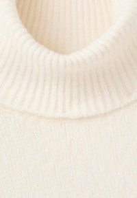 Maglione color crema a collo alto con trama a coste e una vestibilità aderente intorno al collo, che enfatizza il calore e il comfort.