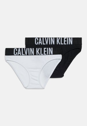 Dwa damskie bikini Calvin Klein, jeden biały i jeden czarny, każdy z elastycznym paskiem z logo marki.