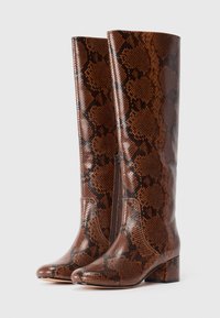 Pair of knee-high brown boots with black snake print pattern, block heels, and side zippers shown on white background.