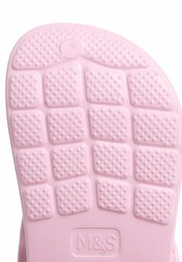 Rosa gummisula med texturerade mönster, små upphöjda bubblor och fyrkantiga sektioner, tydligt märkt med "M&S".