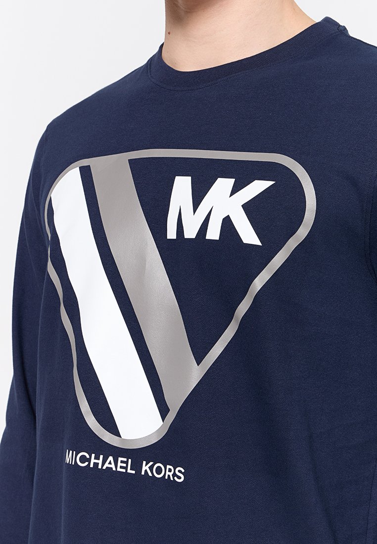 T-shirt a maniche lunghe blu navy realizzato in misto cotone con un grande logo triangolare argento che presenta il testo "MK" e "MICHAEL KORS" sul fronte.