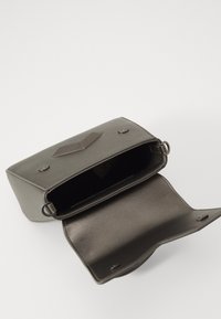 Olivengrønn syntetisk lærveske med rektangulær form, metallhardware og en flat klaff foran. Innvendig har den et romslig rom.