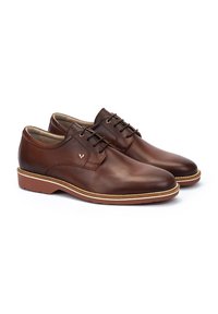 Chaussures en cuir marron avec une finition lisse, bout rond et lacets fins. Dotées d'une semelle de couleur claire avec un bord texturé et un petit logo en accent.