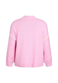 Różowy sweter z dzianiny o luźnym kroju, z kremowymi detalami szycia wzdłuż rękawów i prążkowanym dołem. Miękka tekstura.