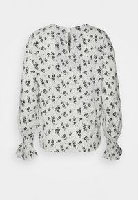 Blusa branca com padrão floral preto e bolinhas. Apresenta mangas longas com punhos franzidos e detalhe de abertura nas costas.