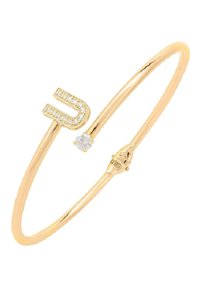 Bracciale rigido in tono dorato con design a forma di U, adornato con pietre preziose trasparenti e una piccola pietra di accento. Finitura liscia, stile minimalista.