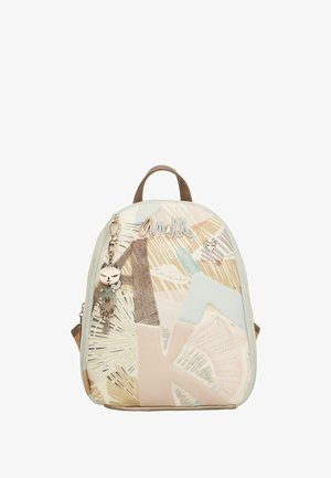 Kleiner, mehrfarbiger Rucksack mit geometrischen Mustern, aus weichem Material gefertigt. Enthält einen Katzenanhänger und einen strukturierten Akzent in der Nähe des Reißverschlusses.