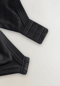 Mustmäär Sportbra, smooth-kanga, reguleeritavate rihmade ja konksuga sulgemistega. Ribitud tekstuur rihmadel, kaarjad servad.