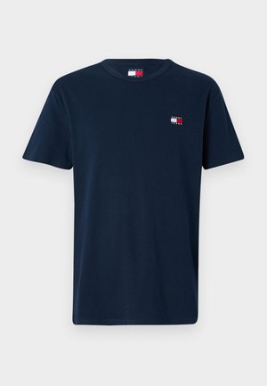 Tamsiai mėlynas trumpomis rankovėmis marškinėlis su apvalia iškirpte, su mažu Tommy Jeans logotipu raudonos, baltos ir mėlynos spalvų ant kairės krūtinės pusės ir apykaklės viduje.