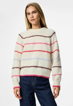 Knit pulover s kremasto osnovo, ki ima vodoravne črte v roza, rdeči, modri in rjavi barvi. S prejo ribana obroba in manšete za teksturo.