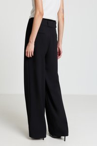 Schwarze Hosen mit weitem Bein aus strukturiertem Stoff, mit einem glatten Bund und Gesäßtaschen, sauber verarbeitet und mit dezenten Nahtdetails.