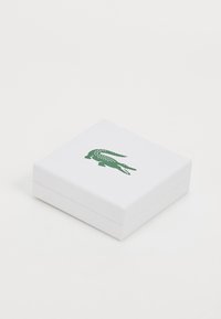 White square box with a textured surface, featuring a green crocodile logo on the top. Closed design, no visible hardware or accents.