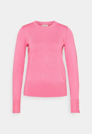 Pull à col rond manches longues en rose vif avec poignets et ourlet côtelés, avec petits boutons dorés sur le poignet gauche.