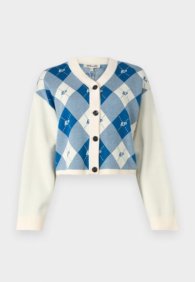 Cardigan raccourci en crème et bleu avec un motif en losanges ; il présente des boutons noirs et des poignets côtelés ; fabriqué en tissu tricoté doux et texturé.