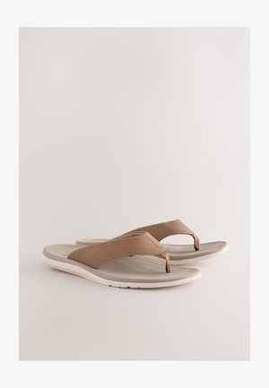 Tongs marron avec des brides synthétiques texturées et une semelle coussinée de couleur blanc cassé. Présentent une semelle intérieure à motif pour une meilleure adhérence et confort.