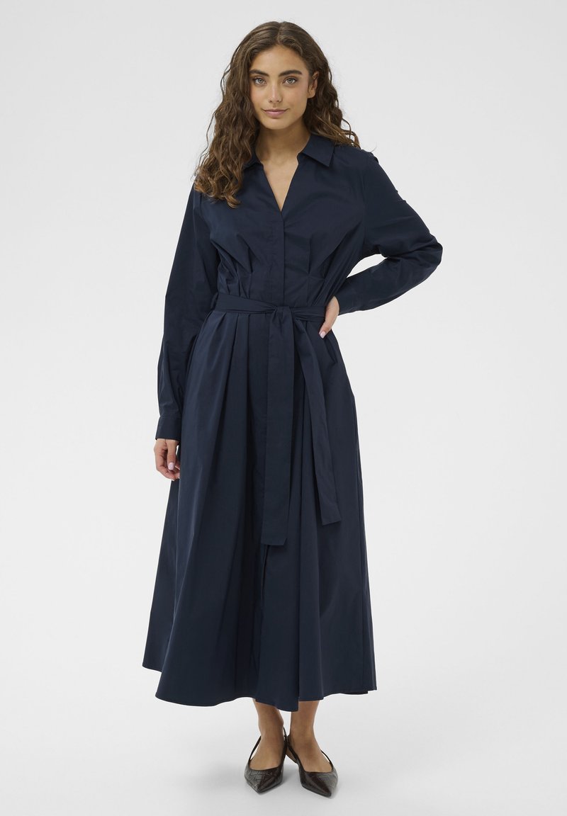 Marineblaues Hemdblusenkleid mit langen Ärmeln, durchgehender Knopfleiste, tailliertem Gürtel und fließendem Rock, aus glattem Baumwollstoff gefertigt.