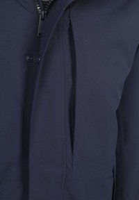 Navyblauwe jas met rits-sluiting, knoopdetail en een gladde, gestructureerde stof. Inclusief een zijzak en op maat gemaakte naden.