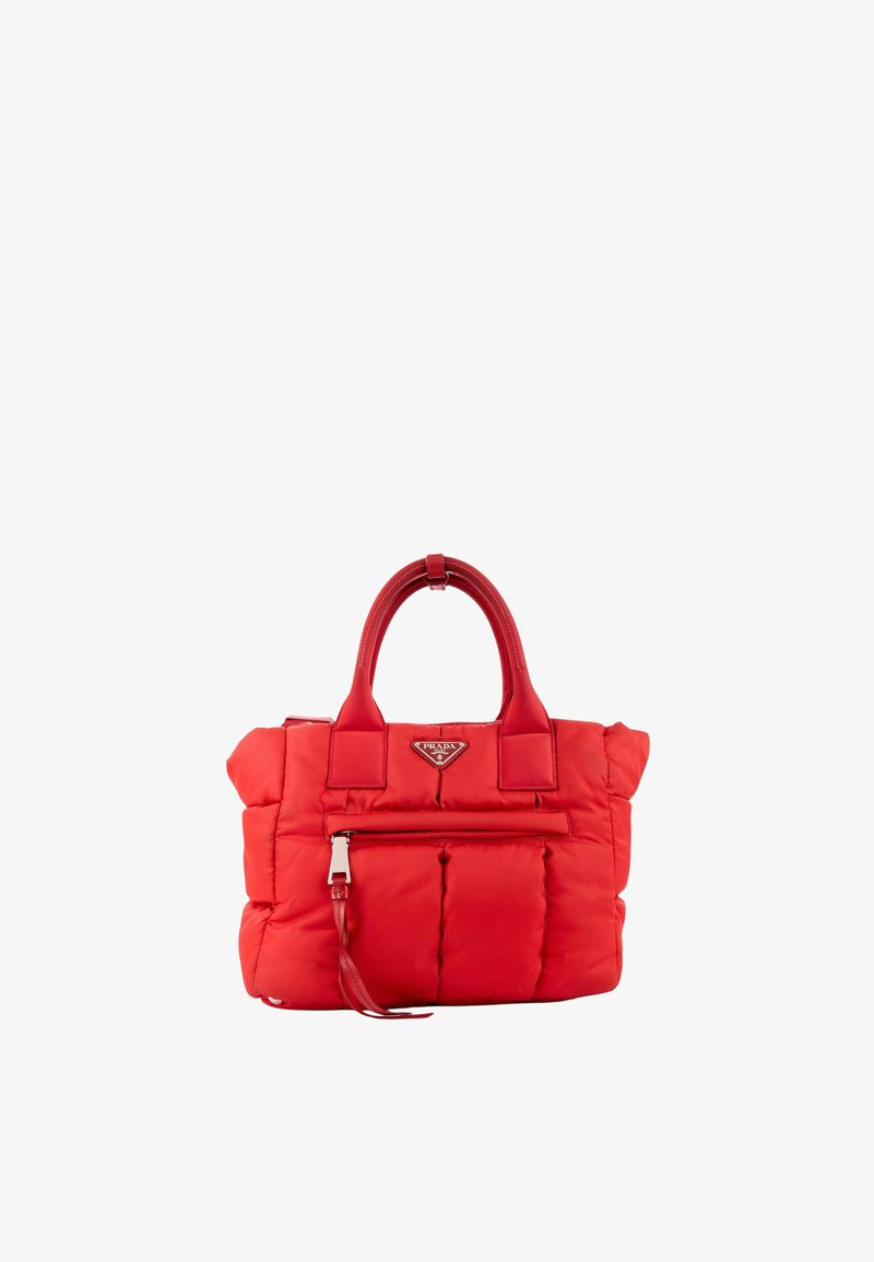 Sac à main matelassé rouge Prada avec poignées supérieures, poche zippée à l'avant et plaque triangulaire avec logo Prada sur fond blanc.